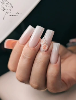 Jasnoróżowy manicure ze zdobieniami wykonany w salonie